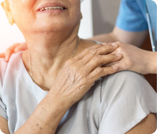 A support worker gently consoling an elderly person, offering comfort and reassurance.